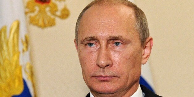 Russia's President Vladimir Putin looks on in the Novo-Ogaryovo residence outside Moscow, early on July 21, 2014, while reco