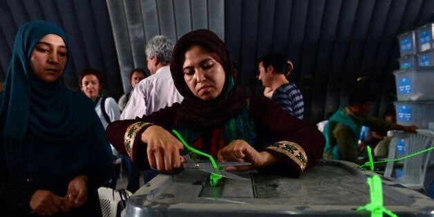 An Afghan election commission worker cuts open the seals to a box containing ballot papers for an audit of the presidential run-off votes at a counting centre in Kabul on July 17, 2014. Afghanistan on July 17 began a massive audit of 8.1 million ballots cast in the run-off round of its controversial presidential vote, hours after a brazen Taliban raid on Kabul's airport. The audit is aimed at reversing a destabilising political crisis that has threatened to widen the country's ethnic fissures as NATO winds down its deployment after more than a decade of war. AFP PHOTO/Wakil KOHSAR (Photo credit should read WAKIL KOHSAR/AFP/Getty Images)