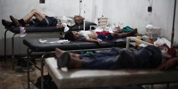 Victims lie on beds as they are treated at a makeshift hospital following reported shelling by Syrian government forces on the central market of the rebel-held city of Douma, northeast of the capital Damascus, on July 30, 2014. The war in Syria has killed more than 170,000 people, and forced nearly half the population to flee. AFP PHOTO / ABD DOUMANY (Photo credit should read ABD DOUMANY/AFP/Getty Images)