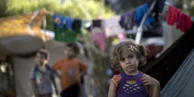 A displaced Palestinian girl stands next to a makeshift tent at the al-Shifa hospital in Gaza City where many Palestinians ha