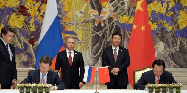 China's President Xi Jinping (back R) and Russia's President Vladimir Putin (back L) attend an agreement signing ceremony in Shanghai on May 21, 2014, with Gazprom CEO Alexei Miller (front L) and Chinese state energy giant CNPC Chairman Zhou Jiping (front R) signing an agreement. China and Russia signed today a monumental, multi-decade gas supply contract in Shanghai, CNPC said, with reports saying it could be worth as much as $400 billion. AFP PHOTO / RIA-NOVOSTI / POOL ALEXEY DRUZHININ (Photo credit should read ALEXEY DRUZHININ/AFP/Getty Images)