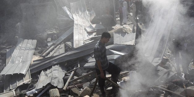 Palestinians inspect the wreckage of a building following an Israeli strike, in Rafah, in the southern Gaza Strip on August 2, 2014. A fresh wave of violence killed dozens in Gaza after the collapse of a UN and US backed ceasefire, officials said, as Hamas denied it kidnapped an Israeli soldier AFP PHOTO/ SAID KHATIB (Photo credit should read SAID KHATIB/AFP/Getty Images)