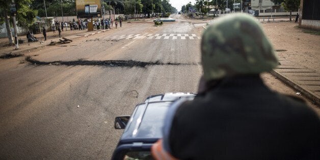 A member of the Central African republic National Gendarmerie patrols on his truck in an avenue at the Lakengua district of Bangui on May 29, 2014. At least 10 people were killed and several others wounded in clashes on May 28, 2014 in the capital of the strife-torn Central African Republic. The violence erupted during the afternoon close to the Notre-Dame de Fatima church in Bangui, according to a police officer and a military source. AFP PHOTO/MARCO LONGARI (Photo credit should read MARCO LONGARI/AFP/Getty Images)