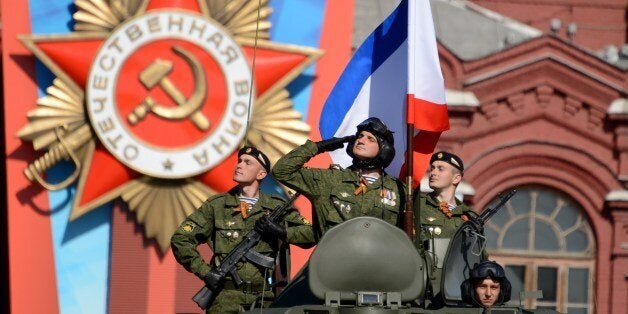 Russian soldiers ride atop their armoured personnel carrier at the Red Square in Moscow, on May 9, 2014, during a Victory Da
