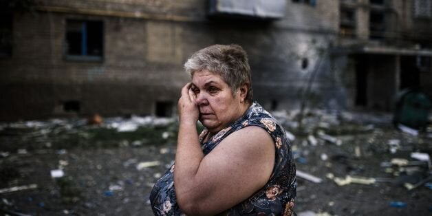 A woman reacts after shelling in the town of Yasynuvata near the rebel stronghold of Donetsk on August 12, 2014. Shelling on a town just north of Donetsk in eastern Ukraine on Tuesday ripped through blocks of flats and set its central market on fire, killing several in an attack that local residents blamed on Ukrainian forces. AFP PHOTO / DIMITAR DILKOFF (Photo credit should read DIMITAR DILKOFF/AFP/Getty Images)