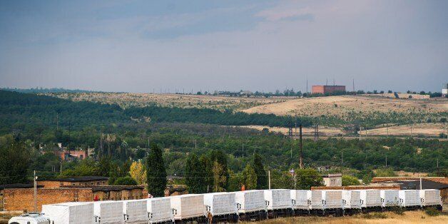 Lorries part of a Russian humanitarian convoy are parked not far from a checkpoint at the Ukrainian border some 30 km outside the town of Kamensk-Shakhtinsky in the Rostov region, on August 18, 2014. A tension between Moscow and Kiev simmering over Russia's decision to try and deliver what it claims to be a huge humanitarian aid convoy that the Ukrainian authorities fear may be used to smuggle in arms to the pro-Kremlin insurgents. AFP PHOTO / DMITRY SEREBRYAKOV (Photo credit should read DMITRY SEREBRYAKOV/AFP/Getty Images)