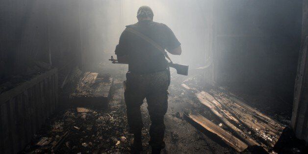 A Pro-Russian rebel walks in a passage at the local market damaged by shelling in Petrovskiy district in the town of Donetsk, eastern Ukraine, Tuesday, Aug. 26, 2014. On Tuesday several shells hit the local market and nearby houses during the mortar duel between Pro-Russian rebels and Ukrainian army. (AP Photo/Mstislav Chernov)
