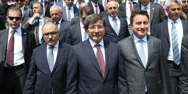 Turkey's new Prime Minister Ahmet Davutoglu (C) and Deputy Prime Minister Ali Babacan (2nd R) leave the Kocatepe Mosque in Ankara after Friday prayers, on August 29, 2014. Turkish President Recep Tayyip Erdogan approved a new cabinet stacked with loyal allies just a day after he moved from premier to head of state, with former Europe minister Mevlut Cavusoglu promoted to foreign minister. Prime Minister Ahmet Davutoglu, who took over Erdogan's former job, announced a ministerial line-up little changed from Erdogan's cabinet, with only four new names. AFP PHOTO/ADEM ALTAN (Photo credit should read ADEM ALTAN/AFP/Getty Images)