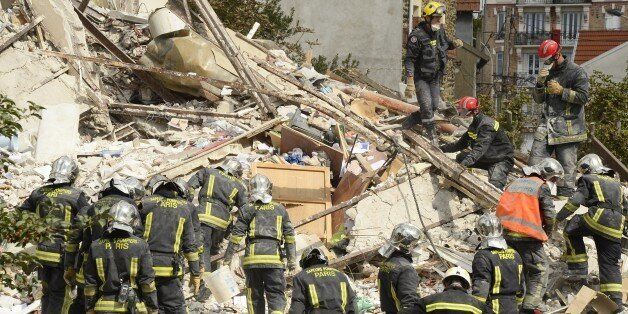 Firefighters search through the rubble of a four-storey residential building that collapsed following a blast in Rosny-sous-Bois in the eastern suburbs of Paris on August 31, 2014. A four-storey residential building collapsed in a Paris suburb following an explosion possibly due to a gas leak, killing at least one child and an elderly woman, local emergency services said. Ten people were also wounded, including four in serious condition, while 11 others are still unaccounted for. AFP PHOTO / BERTRAND GUAY (Photo credit should read BERTRAND GUAY/AFP/Getty Images)