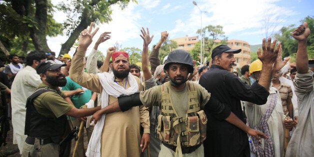 ISLAMABAD, PAKISTAN - SEPTEMBER 1: Pakistani army soldiers take precautions outside the PTV building after army forces removed the protesters, who had been accused of attacking employees and destroying equipment on Monday September 1, 2014 in the capital Islamabad, Pakistan. They had already been told by their leader, preacher Tahir-ul-Qadri, to obey an army request to vacate the building. Pakistan's state television channel PTV resumed broadcasting after briefly being forced off-air, when their offices were raided by anti-government protesters. Since August 14, protesters have been demanding Sharif's resignation but the leading figure in the protest, cricketer turned politician Imran Khan, has denounced the attack on the PTV offices. (Photo by Metin Aktas/Anadolu Agency/Getty Images)