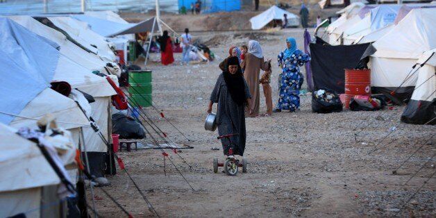 An Iraqi woman, who fled violence in the northern city of Tal Afar, walks through the Bahrka camp, 10 km west of Arbil in the autonomous Kurdistan region, on August 30, 2014. About 700,000 Iraqis have gathered in the Kurdish north after being driven from their homes by jihadist fighters, the United Nations said last week as it stepped up a massive aid operation to the region. AFP PHOTO / SAFIN HAMED (Photo credit should read SAFIN HAMED/AFP/Getty Images)