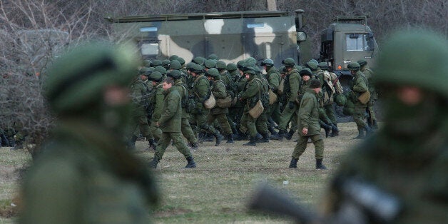 PEREVALNE, UKRAINE - MARCH 05: Troops under Russian command assemble before getting into trucks near the Ukrainian military base they are blockading on March 5, 2014 in Perevalne, Ukraine. Meanwhile armed paramilitary troops, including Cossacks armed with Klashnikov rifles and armoured personnel carriers, have begun digging in at the northern end of Crimea around Armyansk in what seems to be an effort to define the new border between Crimea and Ukraine. (Photo by Sean Gallup/Getty Images)