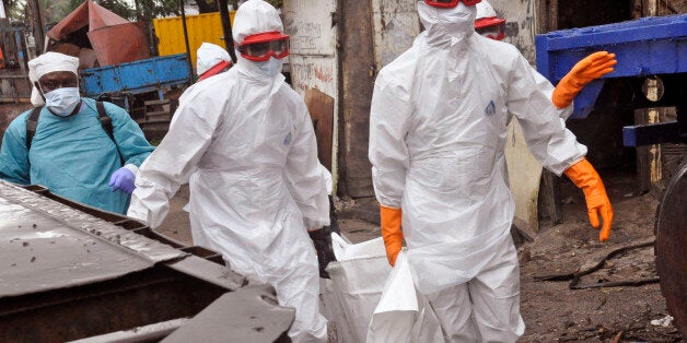 Liberian health workers carry the body of a man that they believe died from the Ebola virus in Monrovia, Liberia, Friday, Aug