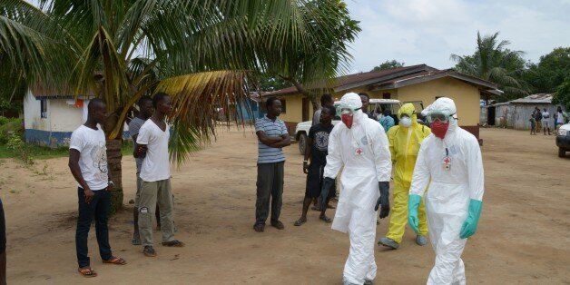 Inhabitants of the small city of Banjol, where three people inficted by Ebola virus died today, look at look at medical workers of the Liberian Red Cross wearing protective suit, on September 4, 2014. The Ebola virus has killed over 1,500 people in four west African countries since the start of the year, spreading through contact with infected bodily fluids.AFP PHOTO / DOMINIQUE FAGET (Photo credit should read DOMINIQUE FAGET/AFP/Getty Images)