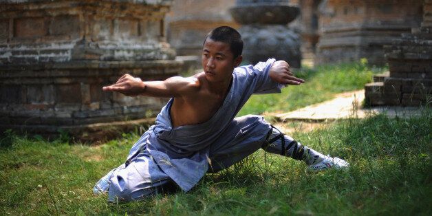 DENGFENG, CHINA - AUGUST 15: (CHINA OUT) A monk practices kung fu at the Shaolin Temple on the Songshan Mountain on August 15, 2009 in Dengfeng of Henan Province, China. Shaolin Temple, built in AD 495 in the period of the Northern and Southern Dynasties (420-581) and located in the Songshan Mountain area, is the birthplace of Shaolin Kung Fu. Shaolin Kung Fu, with its incredible strength, vitality and flexibility, is expecting to be included in the UNESCO intangible heritage list. (Photo by China Photos/Getty Images)