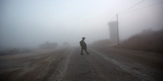 An Israeli soldier walks near the Quneitra border crossing in the Israeli occupied Golan Heights on August 31, 2014. Israel downed a drone over the occupied Golan Heights, the army said, amid mounting tension on the UN-patrolled armistice line with Syria on the strategic plateau. AFP PHOTO/ MENAHEM KAHANA (Photo credit should read MENAHEM KAHANA/AFP/Getty Images)