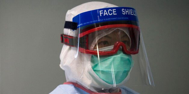 A doctor wearing protective gear takes part in a drill of handling a patient infected with Ebola, in Hong Kong Tuesday, Sept. 2, 2014. An Ebola outbreak in West Africa has killed more than 1,500 people in Guinea, Liberia, Sierra Leone and Nigeria. The university student is Senegal's first case of the dreaded disease. (AP Photo/Tyrone Siu, Pool)