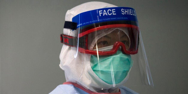 A doctor wearing protective gear takes part in a drill of handling a patient infected with Ebola, in Hong Kong Tuesday, Sept.