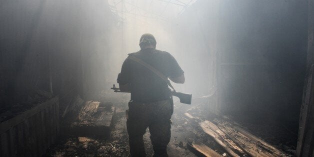 A Pro-Russian rebel walks in a passage at the local market damaged by shelling in Petrovskiy district in the town of Donetsk, eastern Ukraine, Tuesday, Aug. 26, 2014. On Tuesday several shells hit the local market and nearby houses during the mortar duel between Pro-Russian rebels and Ukrainian army. (AP Photo/Mstislav Chernov)