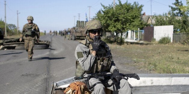 An Ukrainian serviceman smokes a cigaret during a pause in patrol on border of the Donetsk and Luhansk regions near town of D