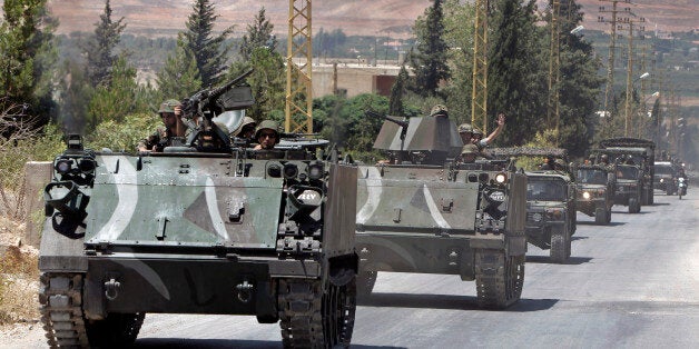 Lebanese army reinforcements arrive to the outskirts of Arsal, a predominantly Sunni Muslim town near the Syrian border in eastern Lebanon, Monday, Aug. 4, 2014. Thousands of Lebanese civilians and Syrian refugees packed cars and pickup trucks Monday, fleeing an eastern border town that was overrun by militants from neighboring Syria as Lebanese troops fight to liberate the area. (AP Photo/Bilal Hussein)