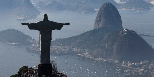 FILE - In this June 27, 2014 file photo, Christ the Redeemer statue is silhouetted next to Sugar Loaf Mountain, in Rio de Janeiro, Brazil. Rio's Archbishop Orani Tempesta presided over a ceremony Friday, July 11, 2014, marking the end to repairs made to the city's famed statue. The $856,000 repair project began six months ago after two fingers and part of the statue's head were chipped during lightning storms. (AP Photo/Leo Correa, File)