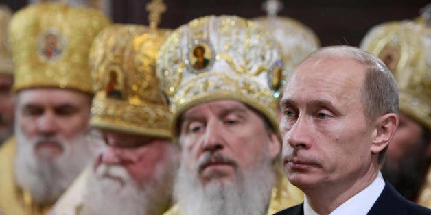 Russian Premier Vladimir Putin (R) attends the enthronement ceremony of Russian Orthodox Patriarch of Moscow and All Russia K