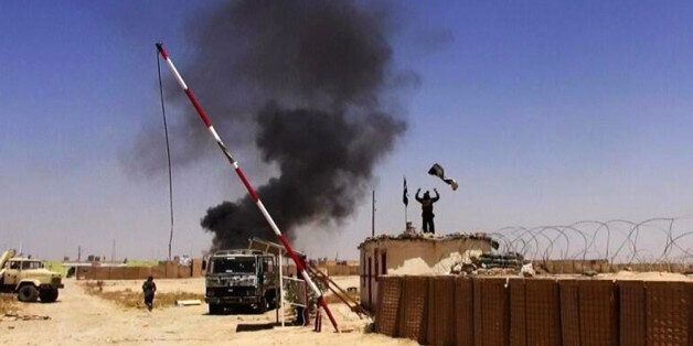 This image posted on a militant news Twitter account on Thursday, June 12, 2014 shows militants from the al-Qaida-inspired Islamic State of Iraq and the Levant (ISIL) people raising their flag at the entrance of an army base in Ninevah Province. Iraq. Fresh gains by insurgents, spearheaded by fighters from the al-Qaida-inspired Islamic State of Iraq and the Levant, come as Prime Minister Nouri al-Maliki's Shiite-led government struggles to form a coherent response after militants overran the country's second-largest city of Mosul, Saddam Hussein's hometown of Tikrit and smaller communities, as well as military and police bases â often after meeting little resistance from state security forces.(AP Photo/albaraka_news)