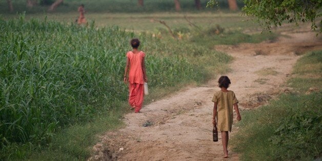 TO GO WITH India-health-women-crime-social,FOCUS BY ABHAYA SRIVASTAVAIn this photograph taken on August 31, 2014, Indian children walk to defecate in an open field in a village in the Badaun district of Uttar Pradesh. Decorated with marigolds and ribbons, 108 toilets unveiled in a tragedy-hit village are a small step in Prime Minister Narendra Modi's push to end open-air defecation for impoverished Indian women. AFP PHOTO/Prakash SINGH (Photo credit should read PRAKASH SINGH/AFP/Getty Images)