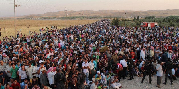 In this photo provided by UNHCR officials and taken on Thursday, Aug. 15, 2013. Syrian refugees cross the border toward Iraq at Peshkhabour border point at Dahuk, 260 miles (430 kilometers) northwest of Baghdad, Iraq. The UN High Commissioner for Refugees (UNHCR) has set up an emergency transit camp in Irbil, where around 2,000 refugees are camping out and UNHCR officials say some thousands of refugees have been streaming into northern Iraq, many coming across a newly-constructed pontoon bridge over the Tigris River at Peshkhabour. (AP Photo/HO)