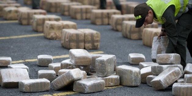 A Colombian anti-drugs police officer checks packages of marijuana, part of a load of five tons seized in the outskirts of Cali, department of Valle del Cauca, Colombia, on February 27, 2012. AFP PHOTO/Luis ROBAYO (Photo credit should read LUIS ROBAYO/AFP/Getty Images)