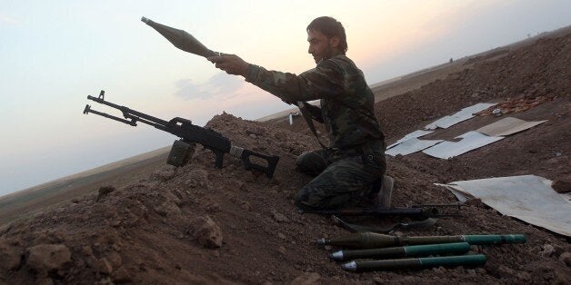 A Peshmerga fighter loads a weapon as he guards a position on front line of fighting with Islamic State (IS) militants 20 kilometres east of Mosul, on August 18, 2014. Kurdish peshmerga fighters backed by federal forces and US warplanes pressed a counter-offensive Monday against jihadists after retaking Iraq's largest dam, as the United States and Britain stepped up their military involvement. AFP PHOTO/AHMAD AL-RUBAYE (Photo credit should read AHMAD AL-RUBAYE/AFP/Getty Images)