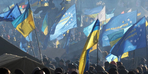 Protesters wave European Union and Ukrainian flags during a rally of the Ukrainian opposition on December 14, 2013 on Independence Square in Kiev, where Pro-European Union protesters have barricaded themselves and have been camping out for three weeks. Ukraine's capital braced for a tense weekend on December 14 as supporters of Ukraine's President Viktor Yanukovych prepared to mount a massive rally right next to the camp of pro-EU protesters who demand his resignation. AFP PHOTO/ VIKTOR DRACHEV (Photo credit should read VIKTOR DRACHEV/AFP/Getty Images)