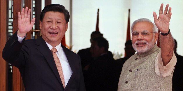 Indian Prime Minister Narendra Modi, right, and Chinese President Xi Jinping wave to the media as Modi welcomes Xi upon his arrival at a hotel in Ahmadabad, India, Wednesday, Sept. 17, 2014. Xi landed in Modiâs home state of Gujarat on Wednesday for a three-day visit expected to focus on India's need to improve worn out infrastructure and reduce its trade deficit. (AP Photo/Ajit Solanki)