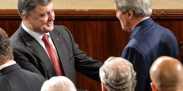 Ukrainian President Petro Poroshenko (L) shakes hands with US Secretary of State John Kerry after addressing a joint session of the US Congress at the Capitol in Washington on September 18, 2014. Poroshenko pleaded with Washington Thursday to provide his country with 'special,' non-NATO security status to help beef up its defenses against aggression from Russia. AFP PHOTO/Nicholas KAMM (Photo credit should read NICHOLAS KAMM/AFP/Getty Images)