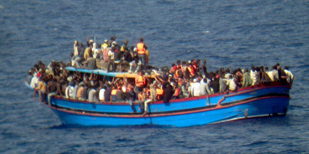 In this photo released by the Italian Navy on Monday, June 30, 2014, and taken on Sunday, June 29, 2014, a boat overcrowded with migrants is pictured in the Mediterranean Sea. The bodies of some 30 would-be migrants were found in in the hold of a packed smugglers' boat making its way to Italy, the Italian navy said Monday. The boat was carrying nearly 600 people, and the remaining 566 survivors were rescued by the navy frigate Grecale and were headed to the port at Pozzallo, on the southern tip of Sicily. (AP Photo/Italian Navy, ho)