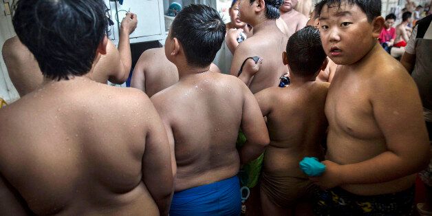 BEIJING, CHINA - JULY 15: Overweight Chinese students gather in the locker room after swimming during training at a camp held for overweight children on July 15, 2014 in Beijing, China. Obesity is a growing problem amongst the burgeoning middle-class in China, and recent studies show that the country is now the second fattest in the world behind the United States. Many parents send their children to special summer camps in an effort to get them into shape and prepare them for the hectic challenges of life in one of the world's largest economies. (Photo by Kevin Frayer/Getty Images)