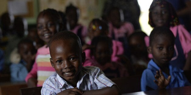 TO GO WITH AFP STORY IN FRENCH BY JEAN-PIERRE CAMPAGNE : 'A Bangui ce matin, Jo Christian est heureux de pouvoir accompagner son fils Ã l'Ã©cole' - Children take part in a lesson in a school downtown Bangui on April 3, 2014. AFP PHOTO / MIGUEL MEDINA (Photo credit should read MIGUEL MEDINA/AFP/Getty Images)