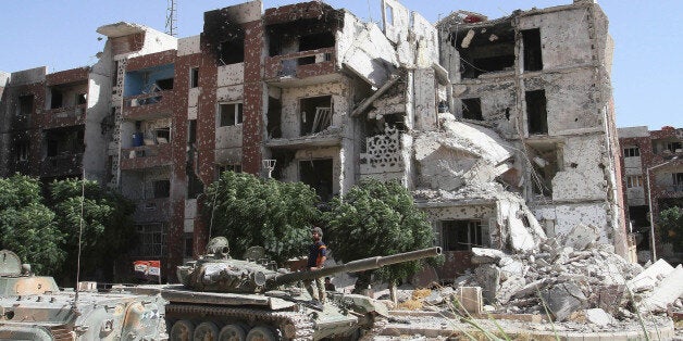 DAMASCUS, SYRIA - SEPTEMBER 25: Tanks of Assad forces are seen around the destroyed buildings during the clashes between Syrian opponents and Assad forces in Adra, Damascus, Syria, on September 25, 2014. (Photo by Kasm Ebu Muhammed/Anadolu Agency/Getty Images)