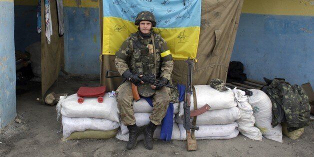 An Ukrainian serviceman sits on position at a checkpoint near Slavyanoserbsk on September 22, 2014. The Ukrainian military said today it was preparing to pull back its guns from the frontline in the separatist east as a fragile truce with pro-Russian insurgents appeared to be taking holdAFP PHOTO/ANATOLII STEPANOV (Photo credit should read ANATOLII STEPANOV/AFP/Getty Images)