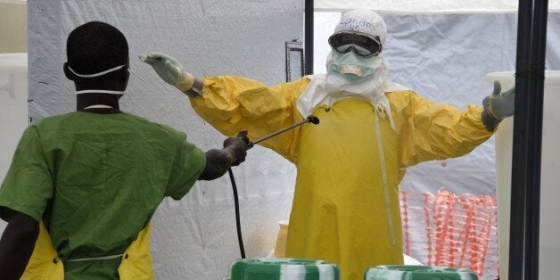 A health worker is decontaminated at the medical center of humanitarian organisation Doctor Without Borders (Medecin sans Fro