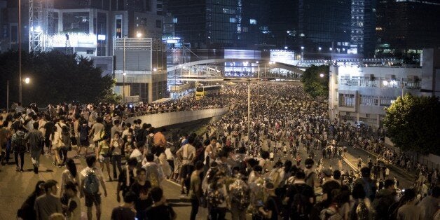 Pro-democracy protesters rally on a major road in the heart of Hong Kong near the government headquarters on September 28, 2014. Police repeatedly fired tear gas after tens of thousands of pro-democracy demonstrators brought parts of central Hong Kong to a standstill on September 28, a dramatic escalation of protests that have gripped the city for days. AFP PHOTO / ALEX OGLE (Photo credit should read Alex Ogle/AFP/Getty Images)