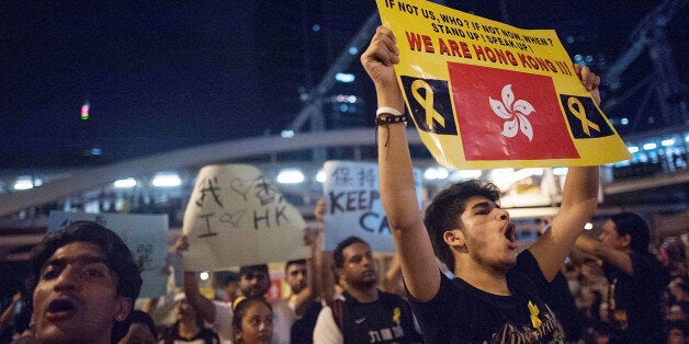 HONG KONG - OCTOBER 01: Pro-democracy protesters chant as they march on a street outside of Hong Kong Government Complex on O