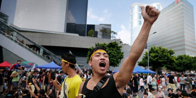 A pro-democracy activist shouts slogans on a street near the government headquarters where protesters have made camp, Wednesd
