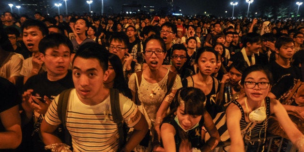 HONG KONG - OCTOBER 2: Pro-democracy protesters chant slogans outside of Hong Kong's Chief Executive C.Y. Leung's office on October 2, 2014. Protesters continued to block main transport routes, after a peaceful night of demonstrations in the Chinese territory. The protests followed a decision last month by China's top legislative body to restrict the nominations for chief executive in 2017. The candidate who wins the popular vote would have to be formally appointed by the central government before taking office. (Photo by Thomas Campean/Anadolu Agency/Getty Images)