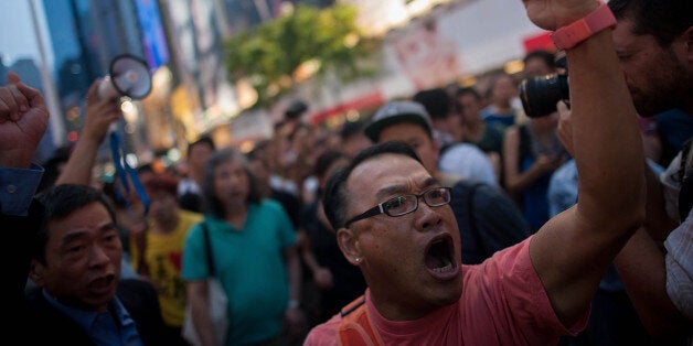 HONG KONG - OCTOBER 03: Anti-Occupy supporters chant at the Occupy camp in Causeway Bay on October 3, 2014 in Hong Kong. Thousands of pro democracy supporters continue to occupy the streets surrounding Hong Kong's Financial district. The protesters are calling for open elections and the resignation of Hong Kong's Chief Executive Leung Chun-ying, who last night agreed to hold talks with the protest leaders in a bid to diffuse the growing unrest. (Photo by Anthony Kwan/Getty Images)