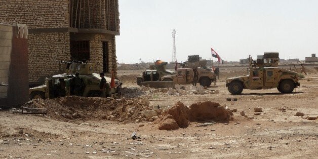 Iraqi security forces and gunmen take positions following clashes with jihadists on September 19, 2014, in Ramadi, the capital of the western province of Anbar. On September 17, a suicide car bomb destroyed a key bridge in Ramadi, a city west of Baghdad where the support of Sunni tribes is seen as vital to any nationwide fightback against the jihadists. AFP PHOTO/AZHAR SHALLAL (Photo credit should read AZHAR SHALLAL/AFP/Getty Images)