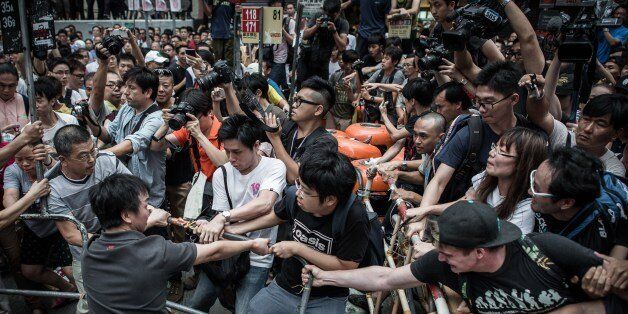 Pro-democracy protesters (R) protect a barricade from rival protest groups (L) in the Mongkok district of Hong Kong on October 4, 2014. Hong Kong has been plunged into the worst political crisis since its 1997 handover as pro-democracy activists take over the streets following China's refusal to grant citizens full universal suffrage. AFP PHOTO / Philippe Lopez (Photo credit should read PHILIPPE LOPEZ/AFP/Getty Images)