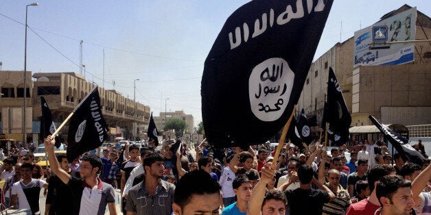 FILE - In this June 16, 2014 file photo, demonstrators chant pro-Islamic State group slogans as they carry the group's flags