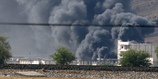 SANLIURFA, TURKEY - OCTOBER 03: A photograph taken from Suruc district of Sanliurfa, southeastern city of Turkey, shows smoke rising from Ayn al-Arab city (Kobani) during clashes between Islamic State of Iraq and the Levant (ISIL) and Kurdish armed groups in Ayn al-Arab, north of Syria, on October 3, 2014. (Photo by Ibrahim Erikan/Anadolu Agency/Getty Images)